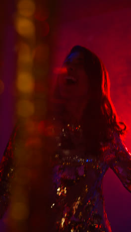 Vertikales-Video-Einer-Frau-In-Einer-Nachtclubbar-Oder-Disco,-Die-Mit-Funkelnden-Lichtern-Und-Trockeneis-Im-Hintergrund-Tanzt